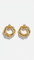Gilded gold statement hoop earrings, perfectly centered horizontally and vertically with equal negative space above and...